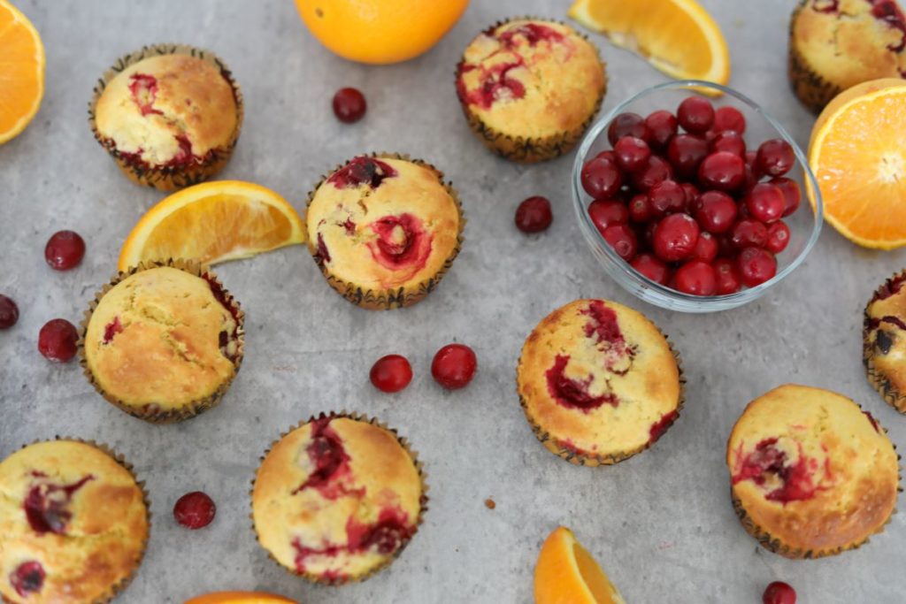 Looking down on cranberry orange muffins with a bowl of cranberries