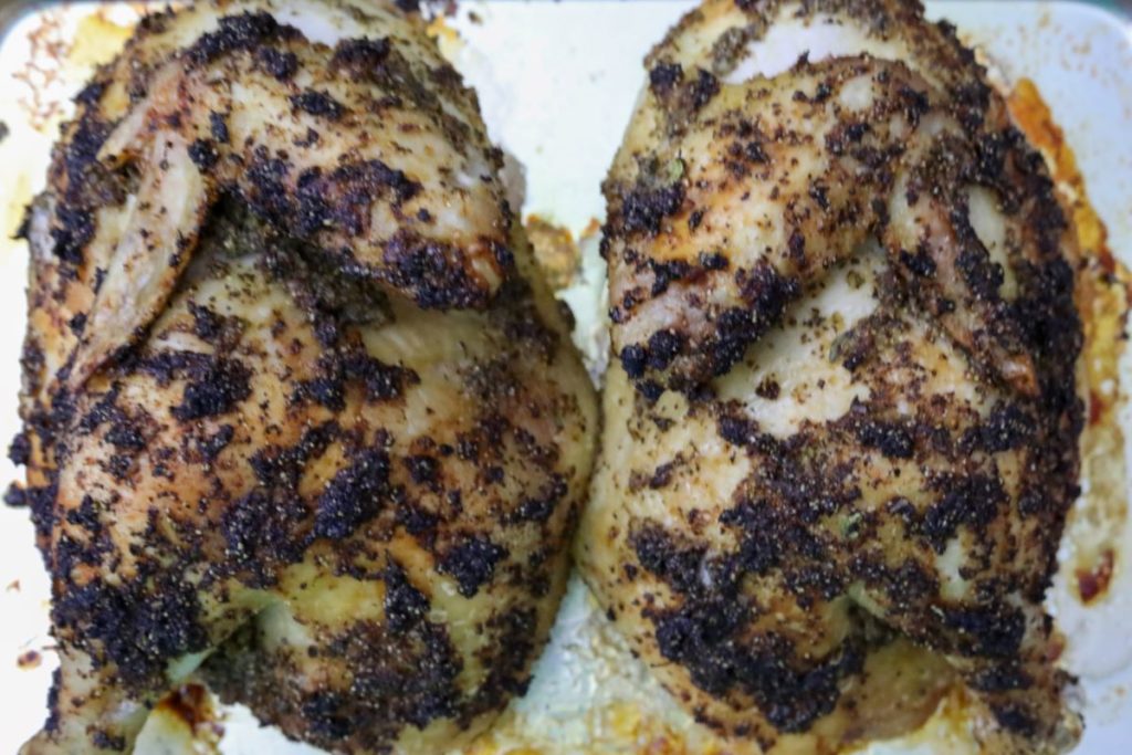 roasted chicken halves on a sheet pan