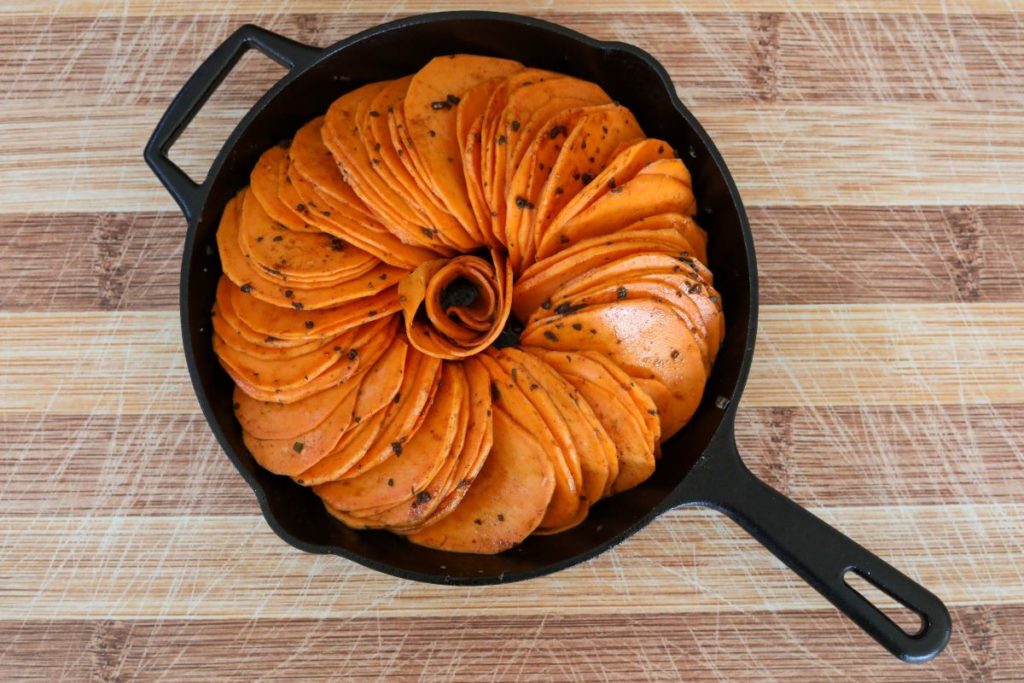 uncooked sage sweet potatoes in a cast iron skillet