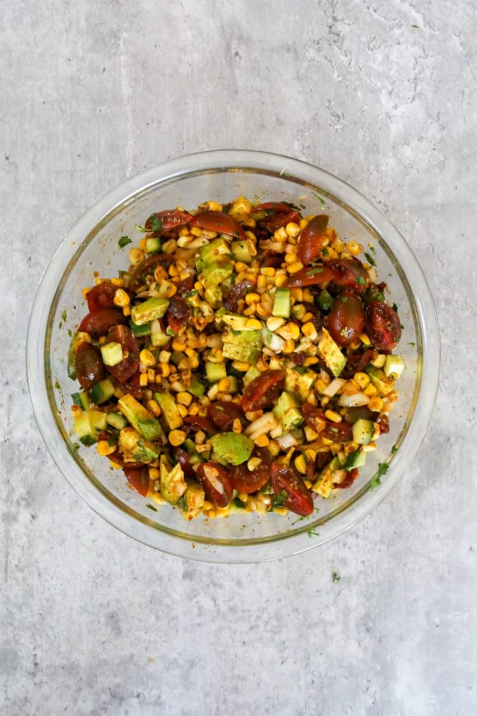 mixed and dressed corn salad in a glass bowl
