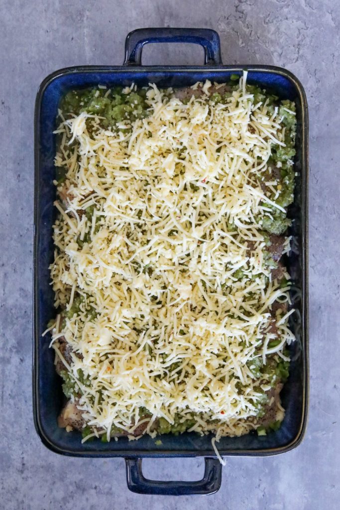salsa verde chicken covered in cheese in a baking dish