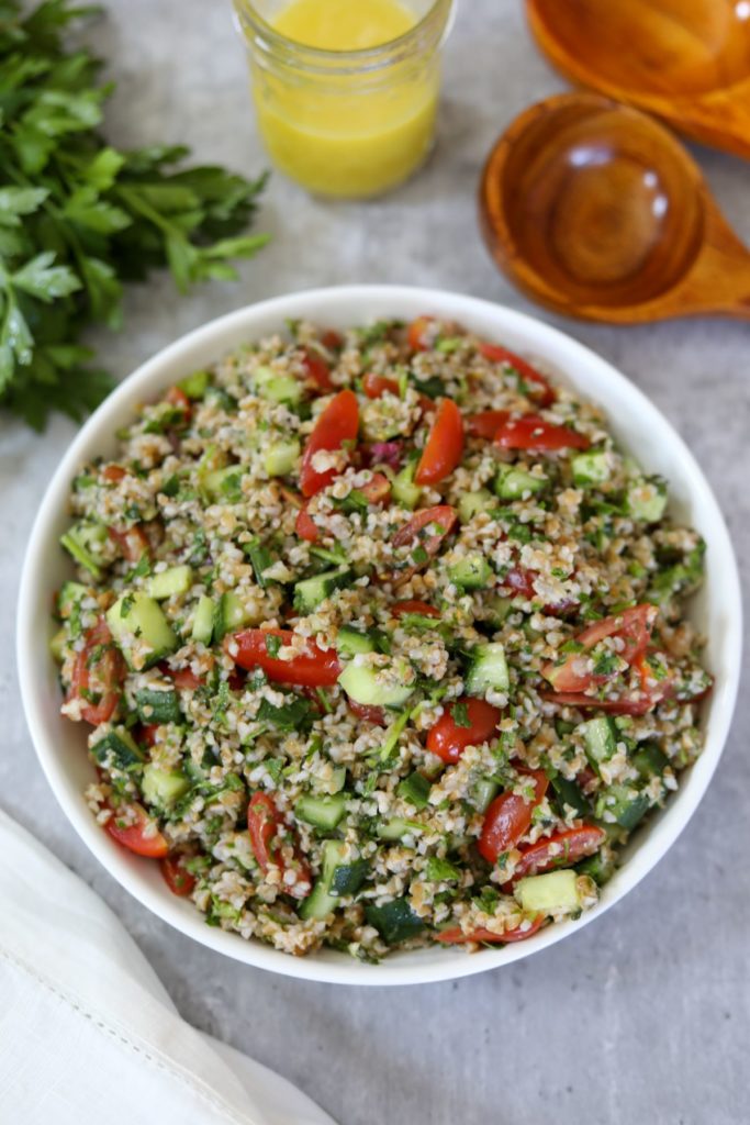A bowl of tabbouleh with wooden spoons