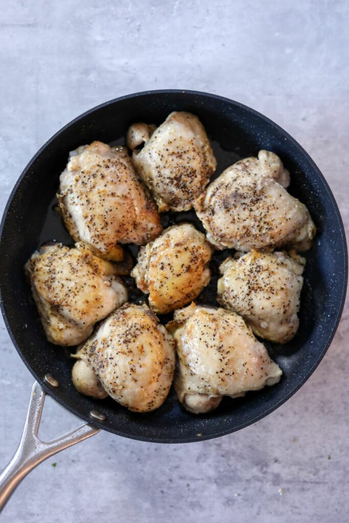 Cooked chicken thighs in a pan
