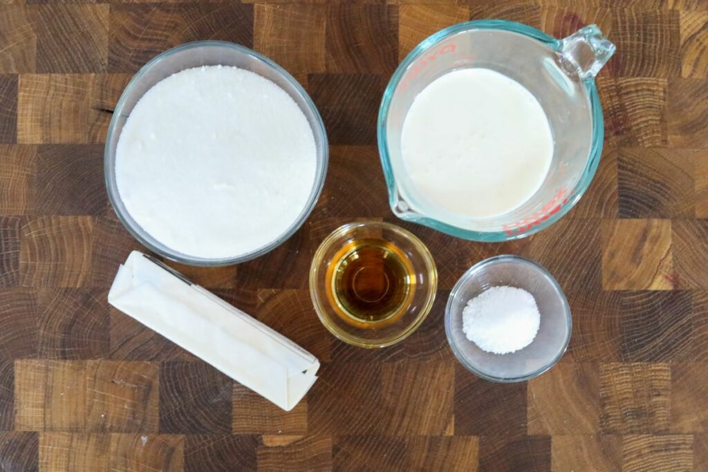 Ingredients for bourbon caramel sauce on a wooden cutting board