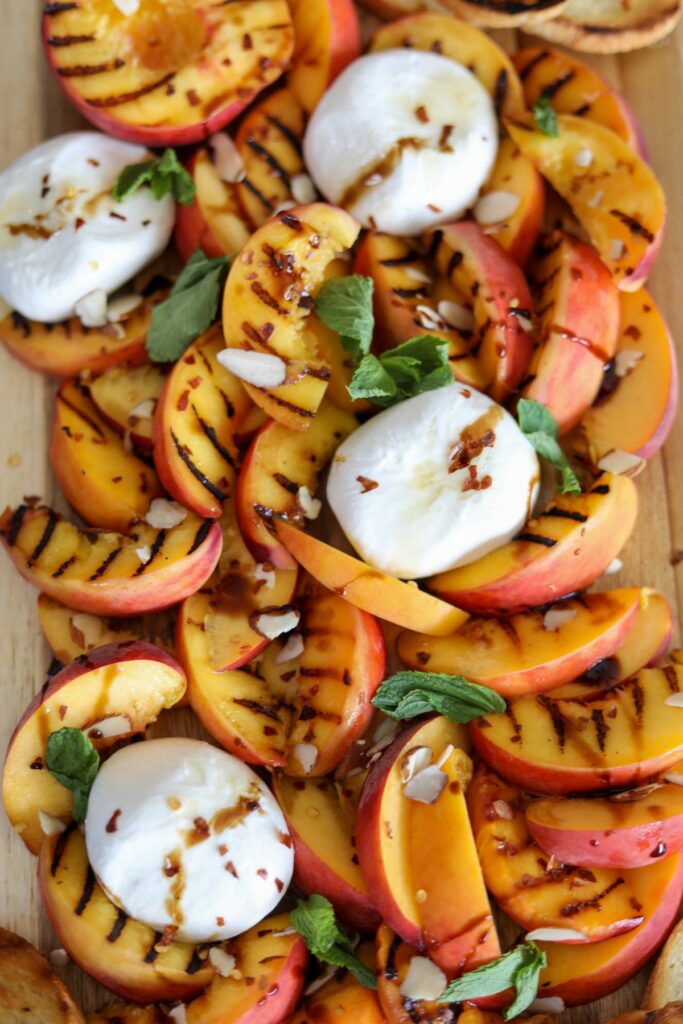 grilled peaches and burrata on a wooden serving bowl