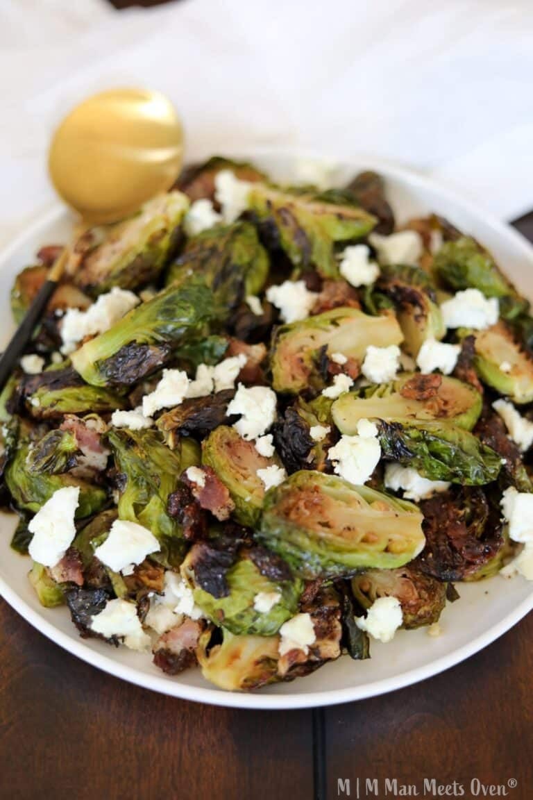 Maple brussels sprouts on a white plate with a gold spoon