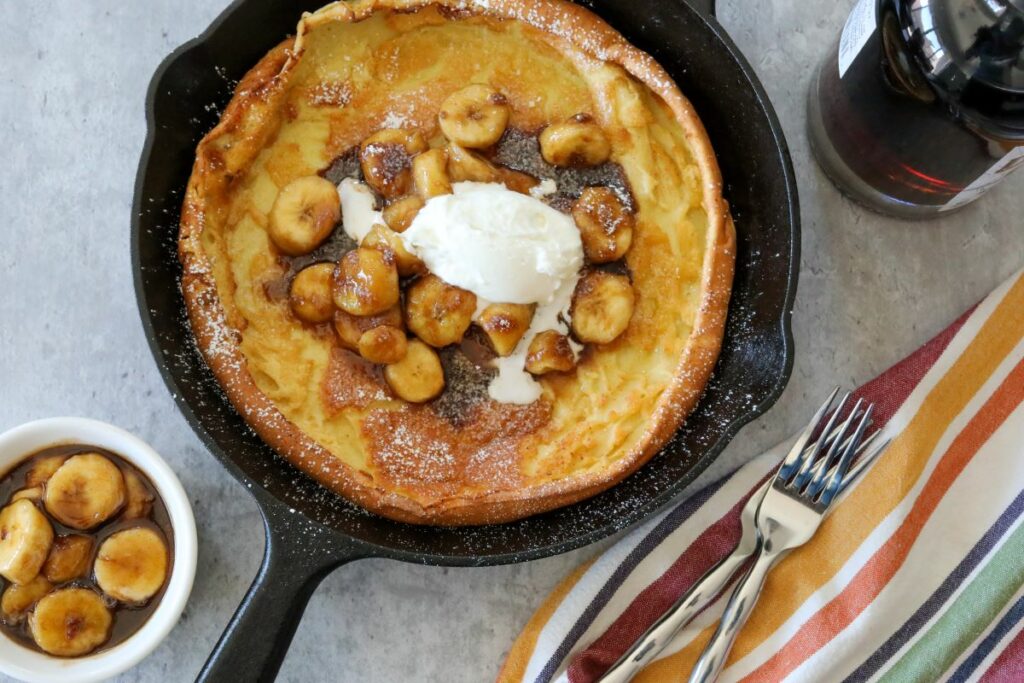 A cast iron skillet with a bananas foster dutch baby