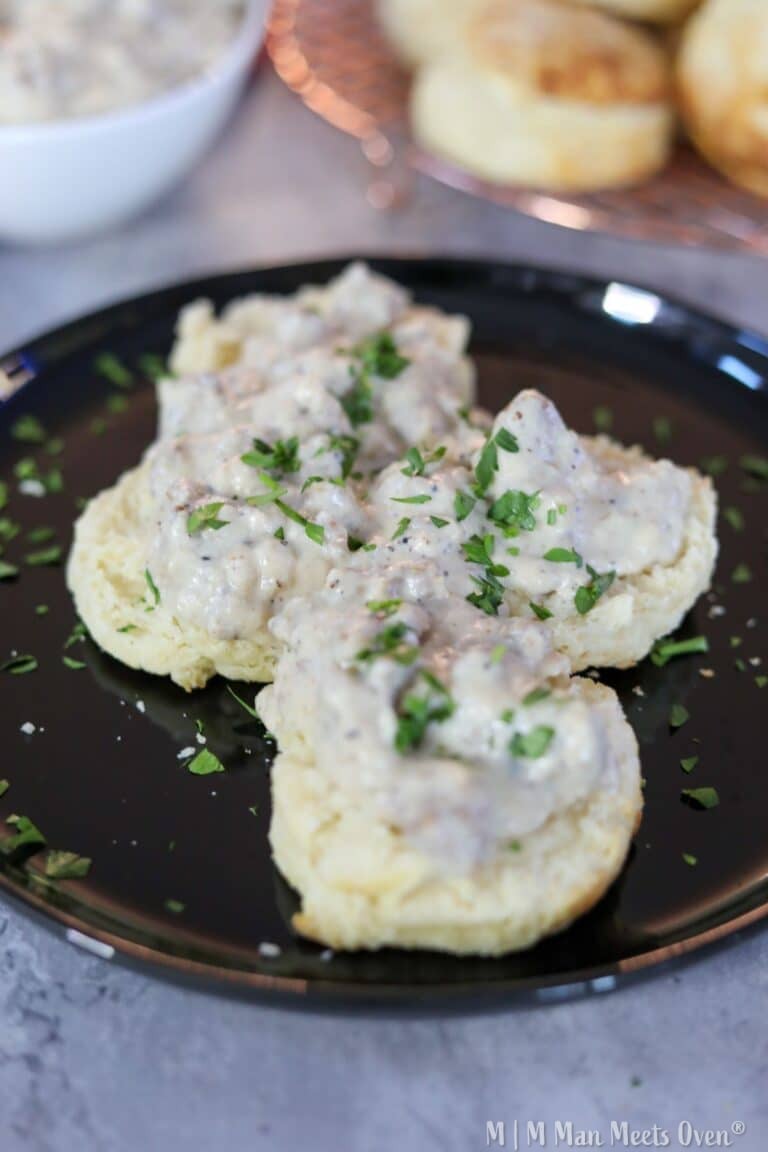 Biscuits and gravy on a black plate