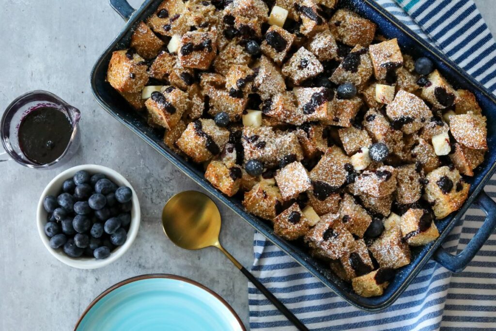 Blueberry French toast in a blue baking dish and a light blue plate