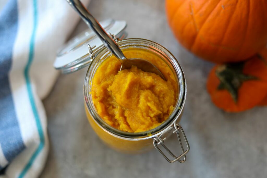 Pumpkin puree in a jar with a spoon
