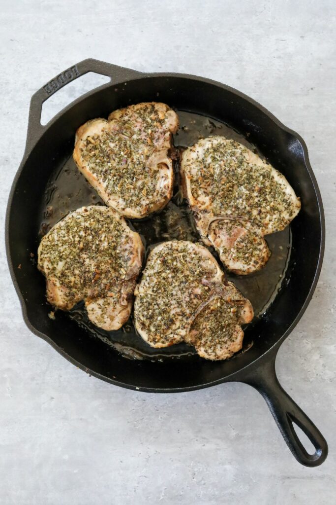 Cooked pork chops in a cast iron skillet
