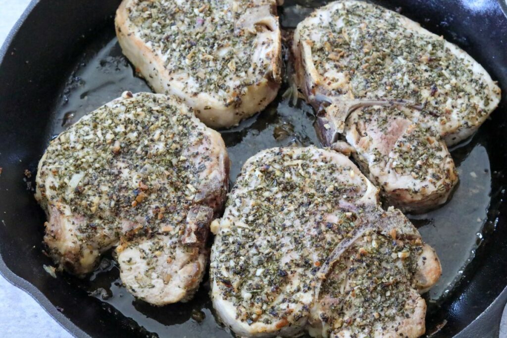 Rosemary pork chops in a cast iron skillet