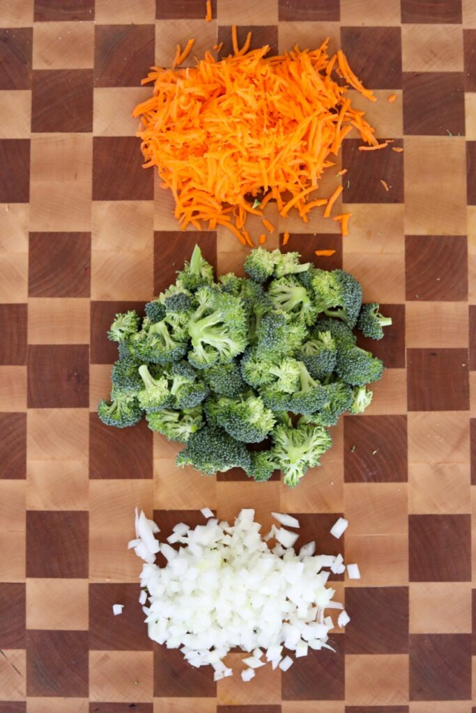 chopped broccoli carrots and onion on a cutting board