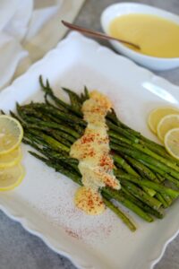 Roasted asparagus with hollandaise on a white platter