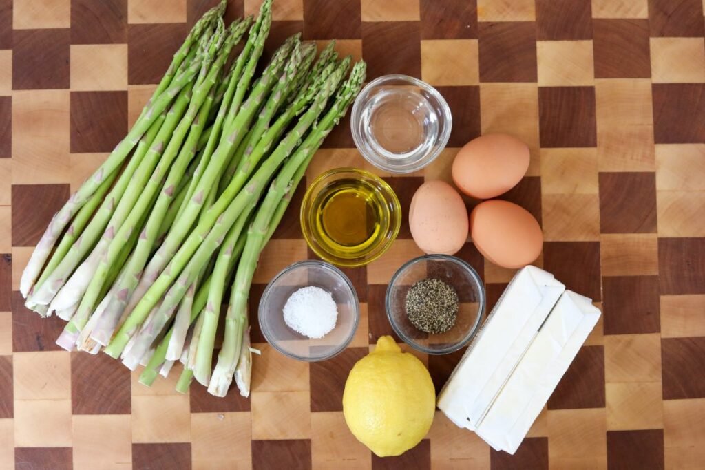 Ingredients for roasted asparagus on a wooden cutting board