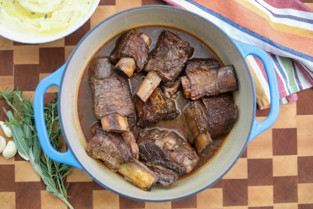 A pot of short ribs with strained braising liquid