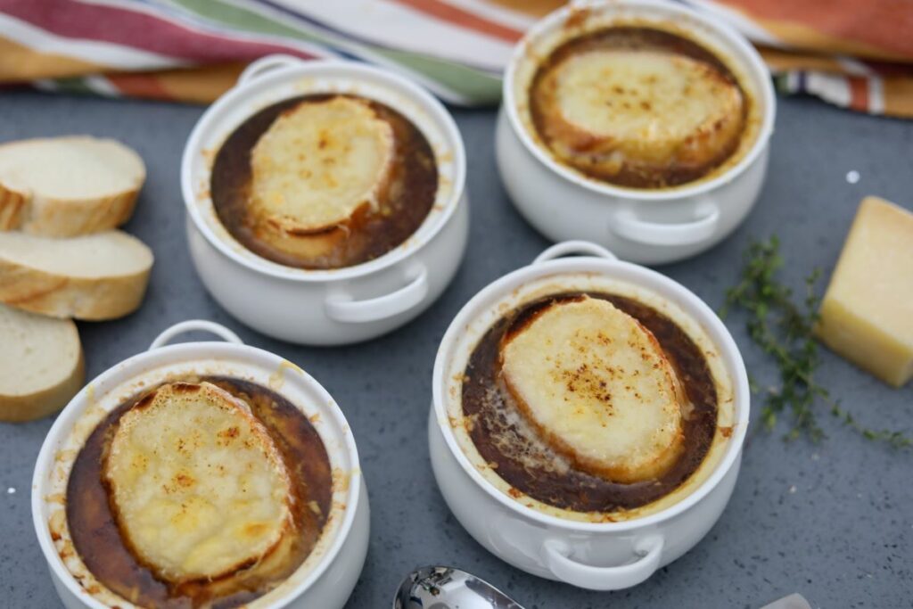 Four bowls of French onion soup with cheese toast on top