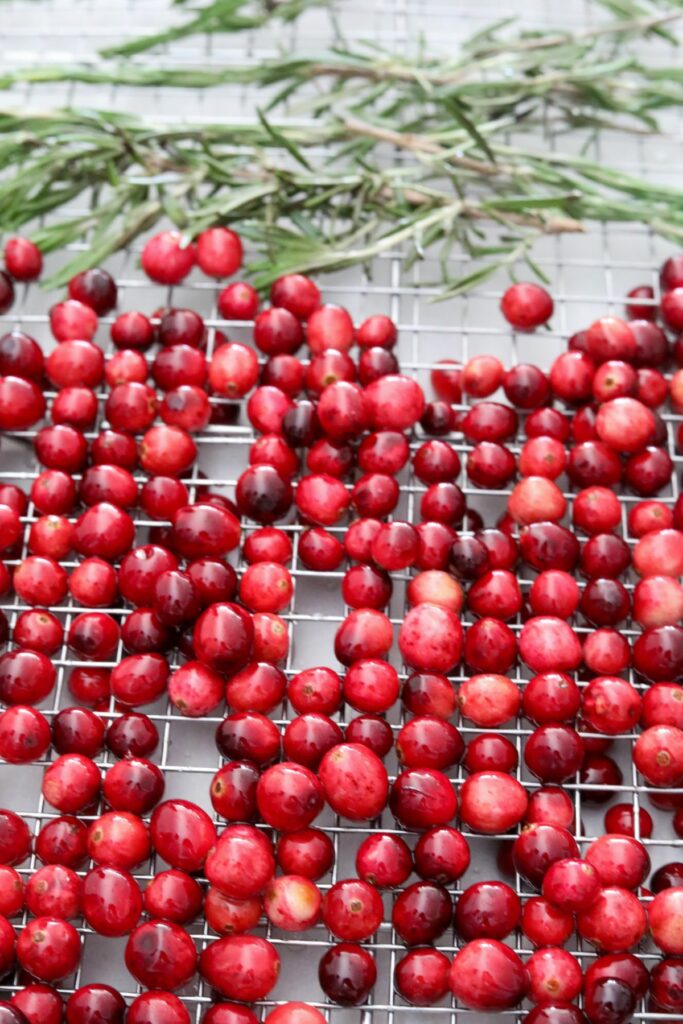 Rosemary and cranberries drying on a baking rack