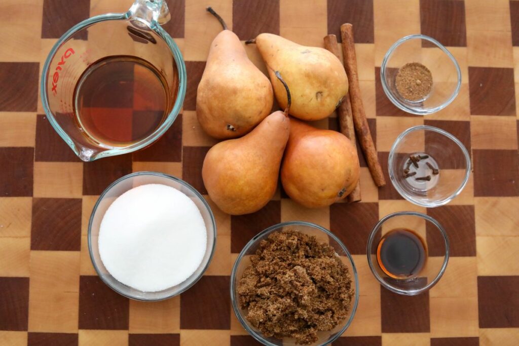 Ingredients for bourbon poached pears on a wooden cutting board