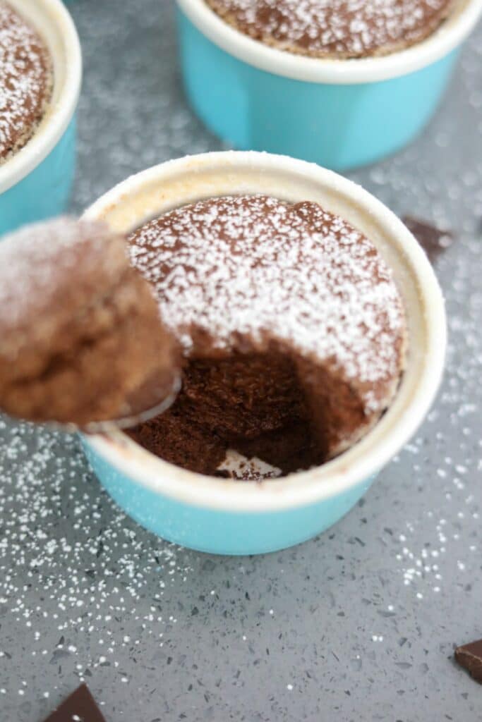 A chocolate souffle with a spoonful removed.