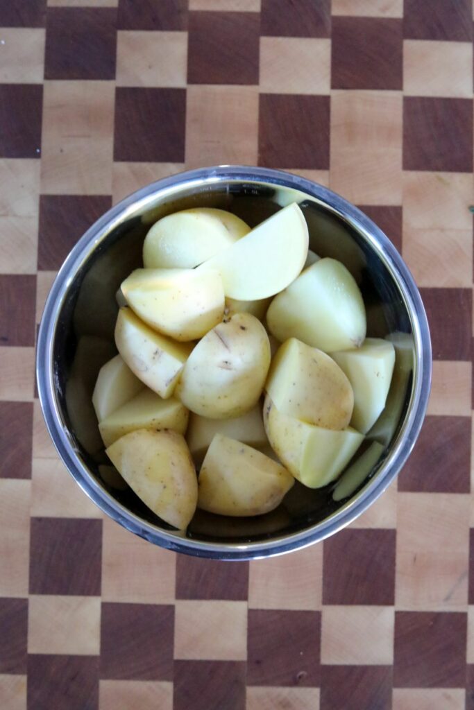 Sliced potatoes in a mixing bowl