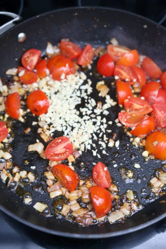 Tomatoes, garlic and cooked shallots in a pan