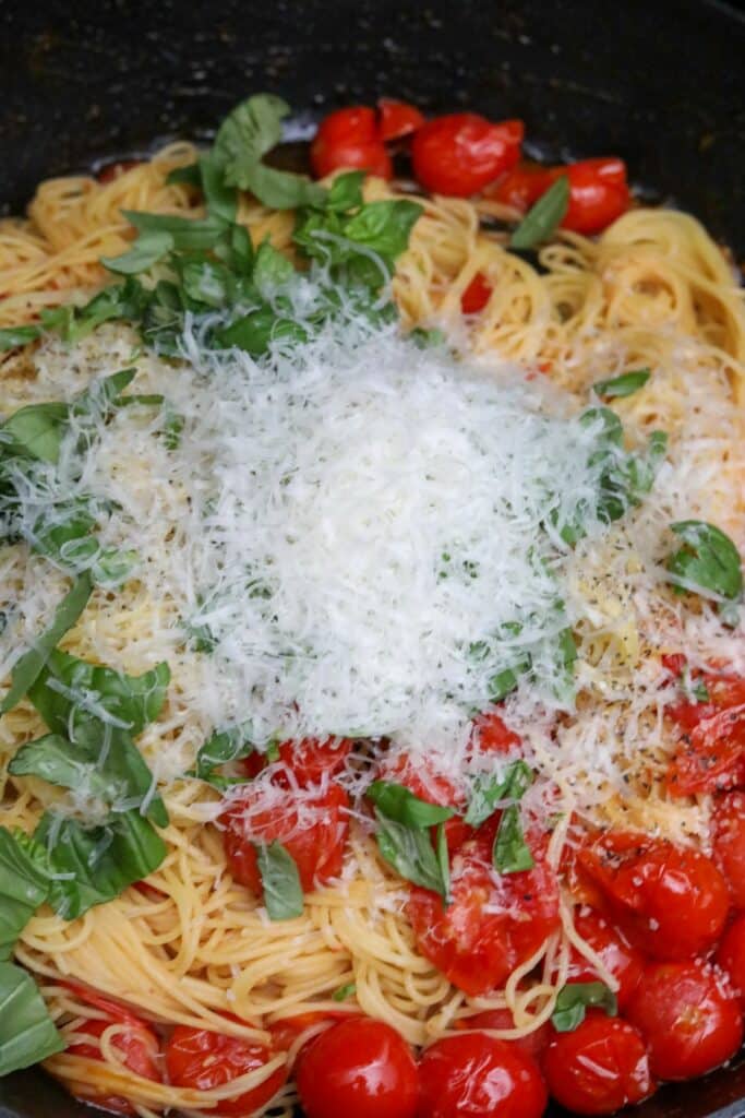 Basil, pasta and parmesan cheese added to the pan