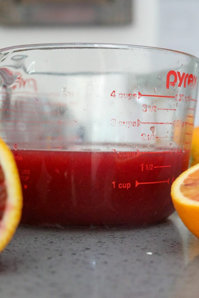 A measuring cup of blood orange juice