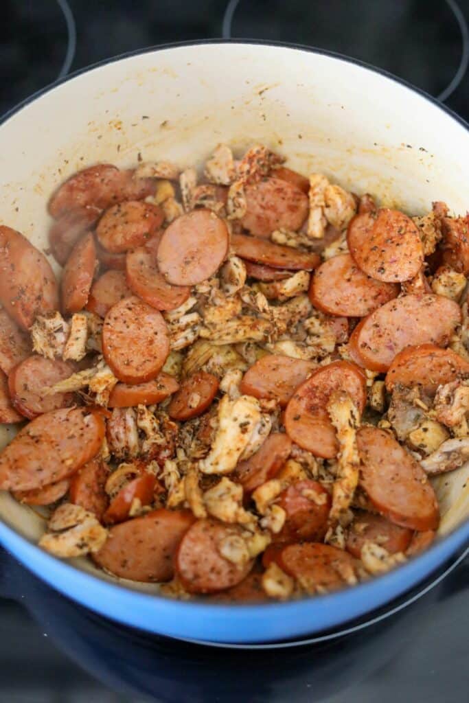 Cooked chicken and andouille sausage in a Dutch oven