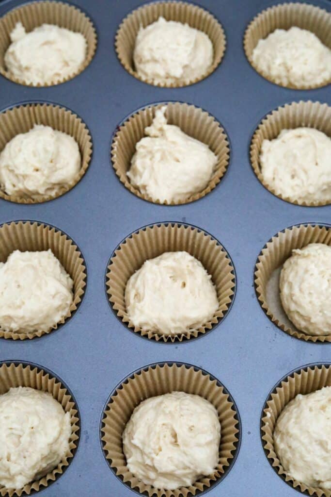 Uncooked cupcake batter in a lined muffin pan