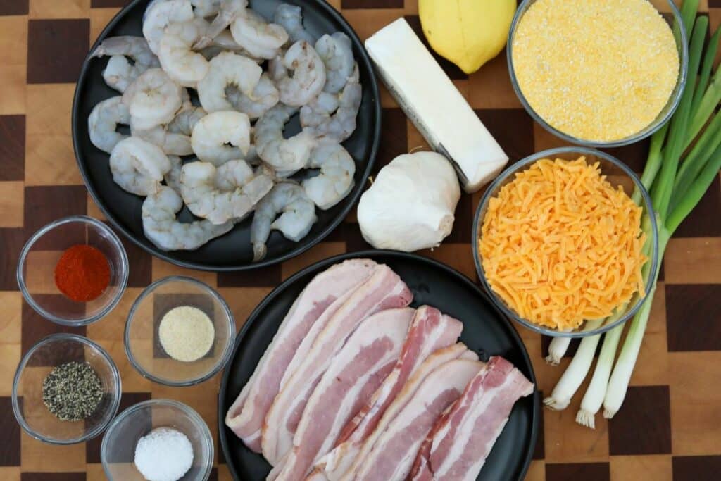Ingredients for shrimp and grits on a wooden cutting board
