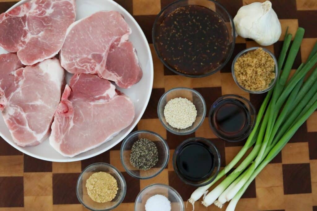 ingredients for teriyaki pork chops on a wooden cutting board