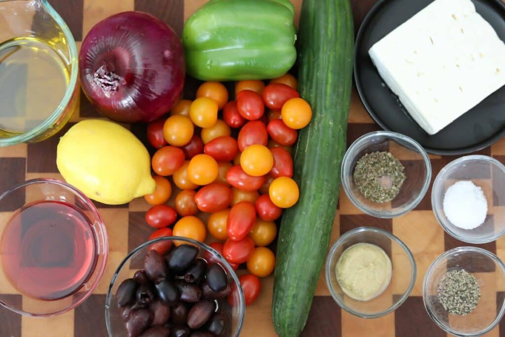 Ingredients for Greek salad on a wooden cutting board