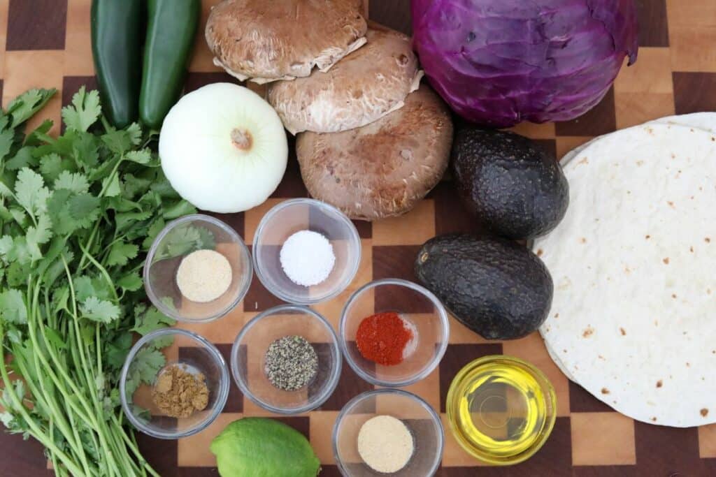 Ingredients for portobello tacos on a wooden cutting board