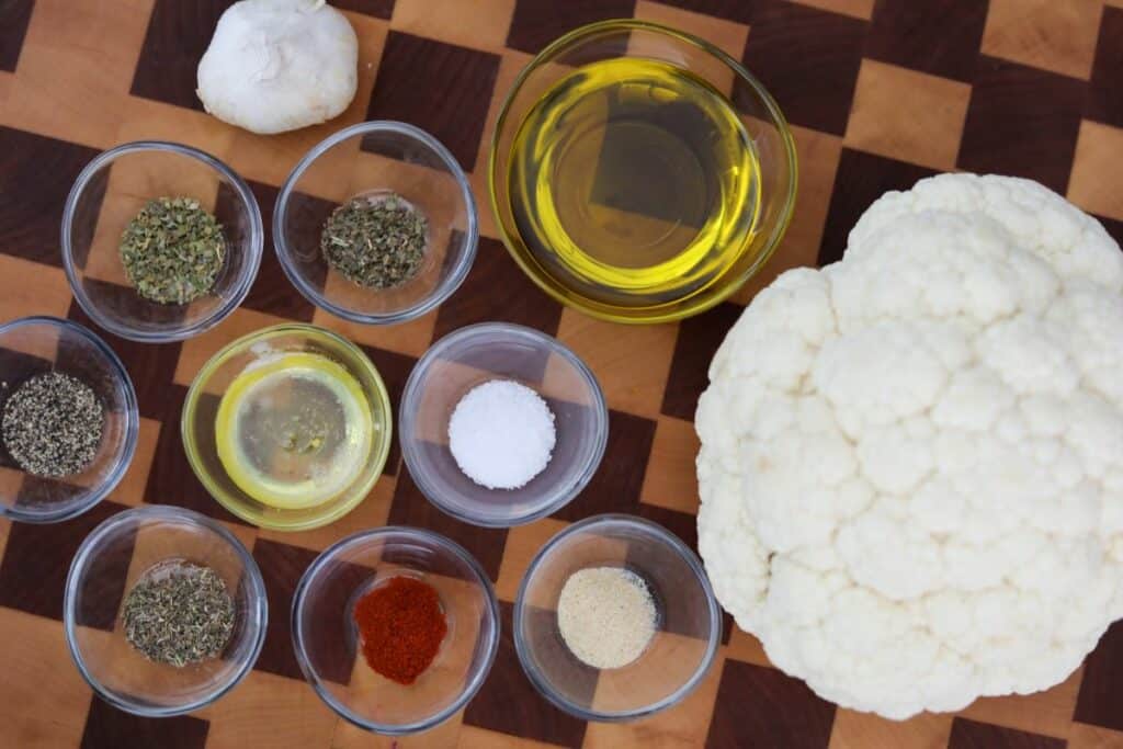 Ingredients for roasted cauliflower on a wooden cutting board
