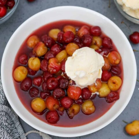 A white bowl of cherries jubilee
