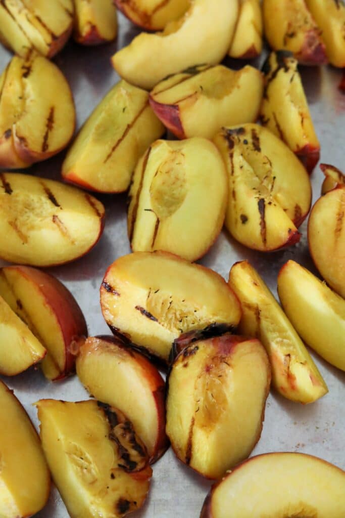 Sliced grilled peaches on a sheet pan