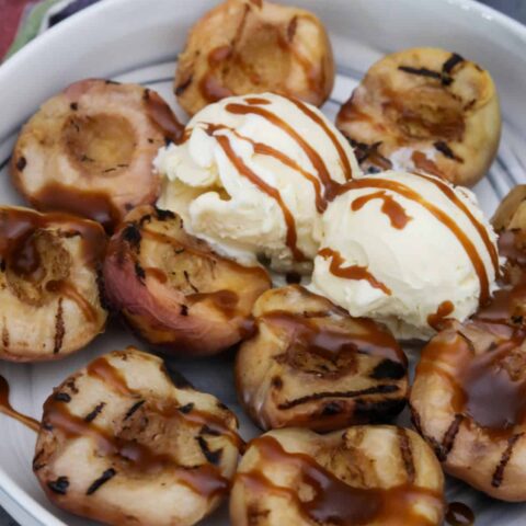Bowl of grilled peaches with 2 scoops of ice cream
