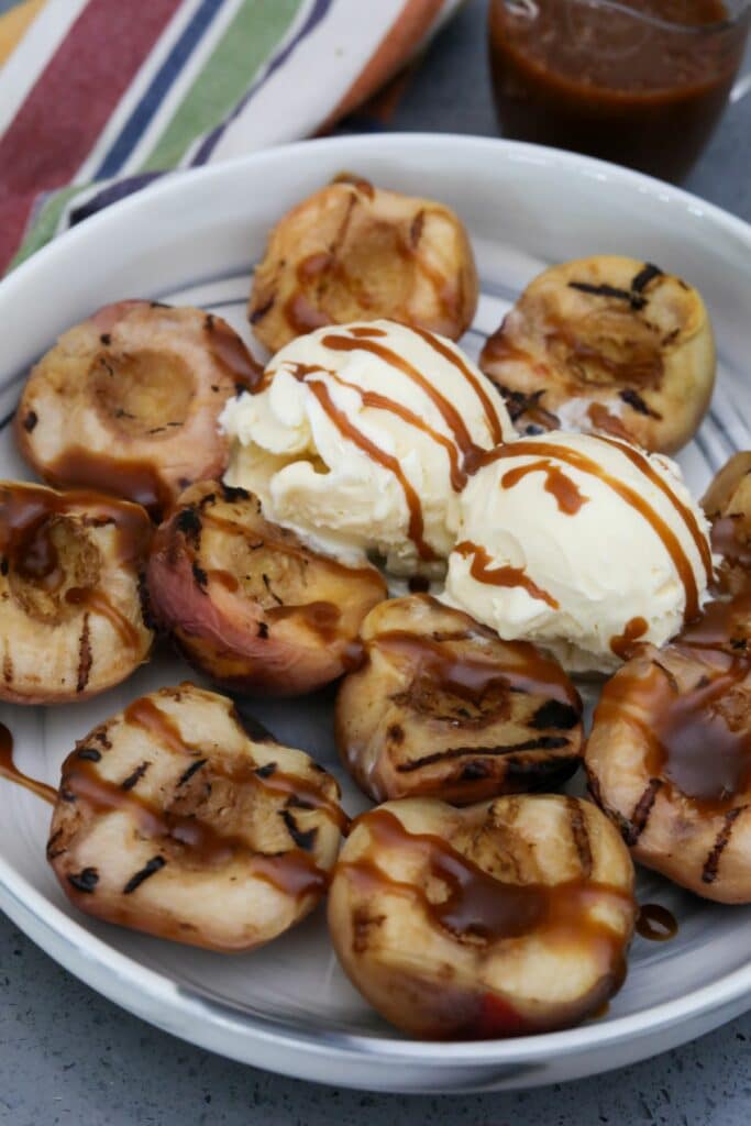 Bowl of grilled peaches with 2 scoops of ice cream