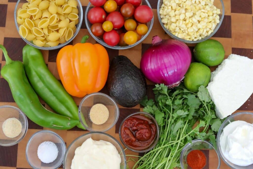 Ingredients for southwest pasta salad on a wooden cutting board