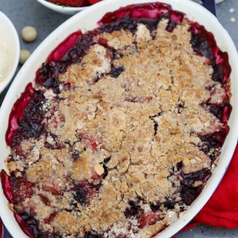 Baked strawberry and blueberry crisp in a blue dish