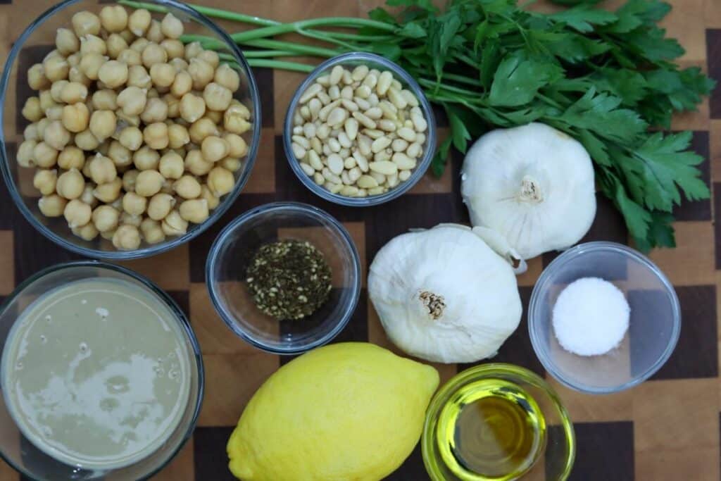 Ingredients for garlic hummus on a wooden cutting board