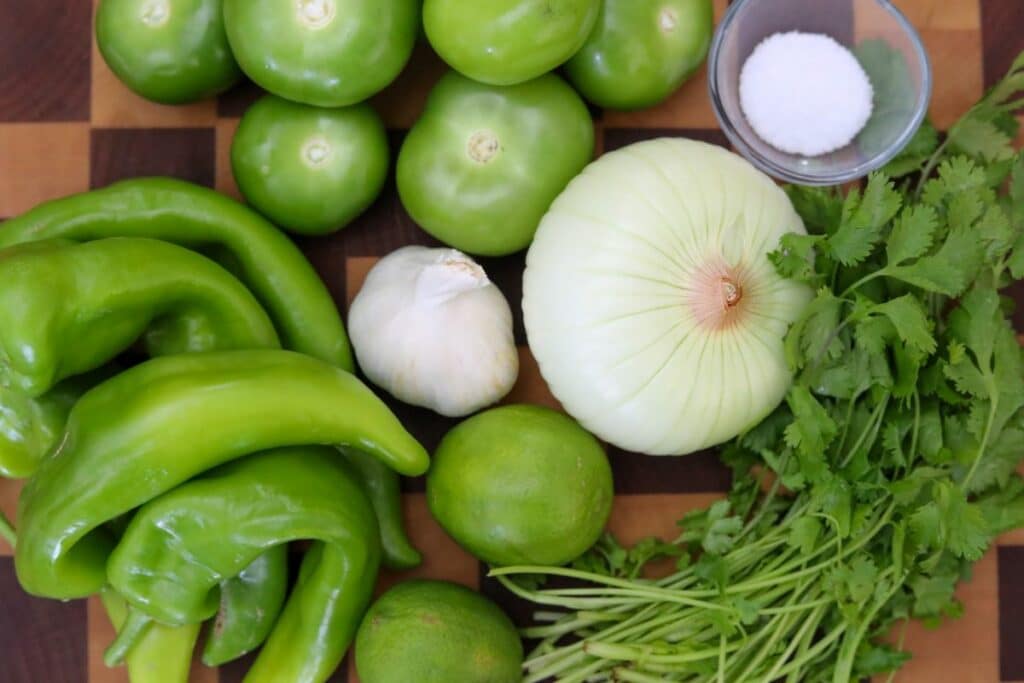 Ingredients for hatch chile salsa verde on a wooden cutting board