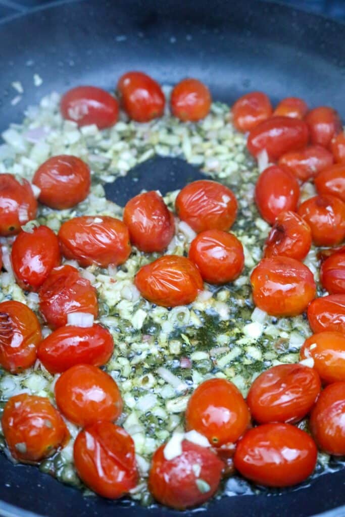 Burst tomatoes and garlic in a pan