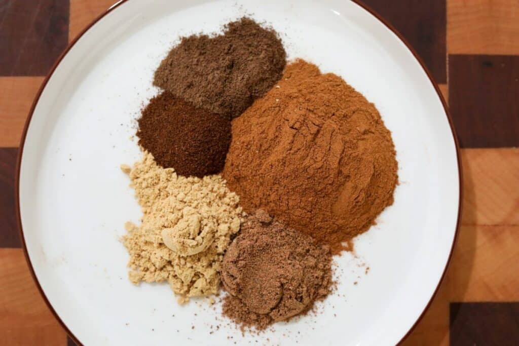 Ingredients for pumpkin spice blend on a white plate
