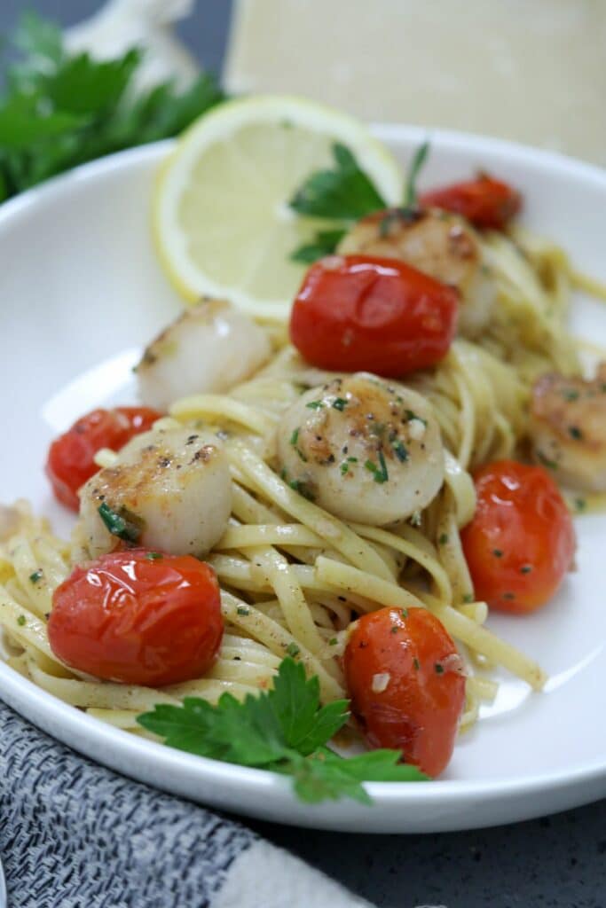 A serving of scallop pasta in a white bowl