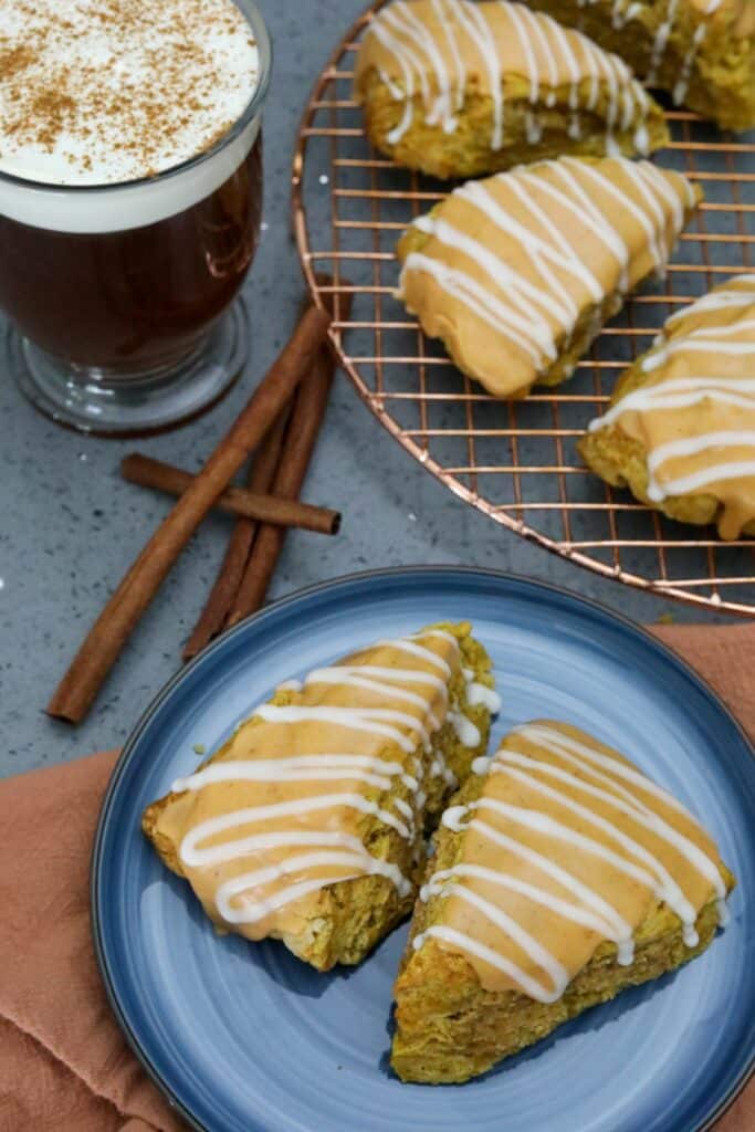 Pumpkin scones on a plat with acup of coffee