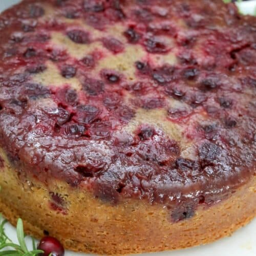 Cranberry walnut upside down cake on a white cake plate