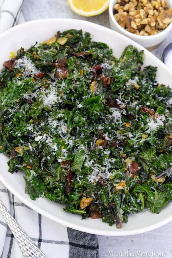 Sautéed kale with bacon and lemon in a white serving platter