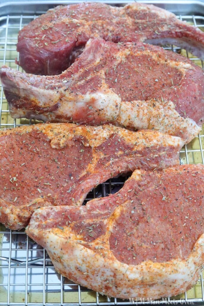 Dry brined pork chops on a baking rack
